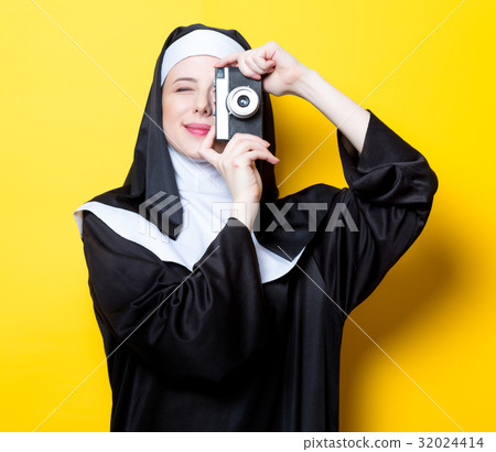 Young happy nun with vintage photo camera Young happy nun with vintage photo camera 32024414