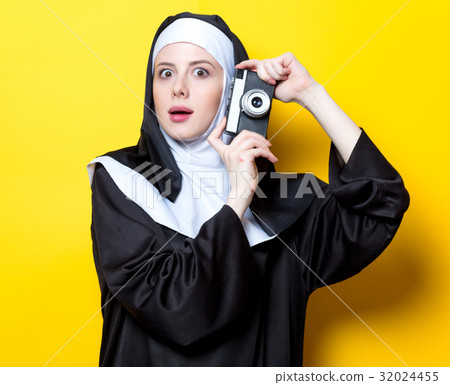 Young surprised nun with vintage photo camera Young surprised nun with vintage photo camera 32024455