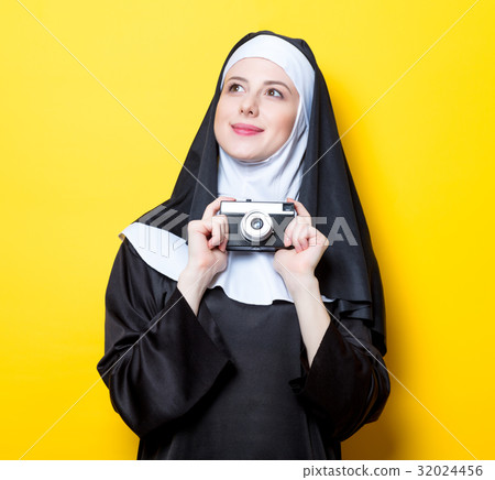 Young happy nun with vintage photo camera Young happy nun with vintage photo camera 32024456