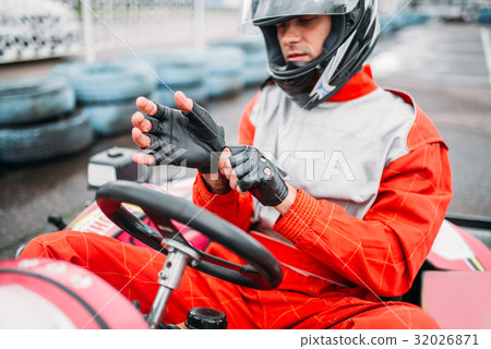 Go-kart driver in helmet on karting speed track Go-kart driver in helmet on karting speed track 32026871