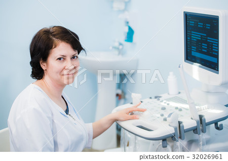 Happy mature female doctor using ultrasound Happy mature female doctor using ultrasound 32026961