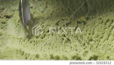 macro of pistachio ice cream being scooped with 32028312