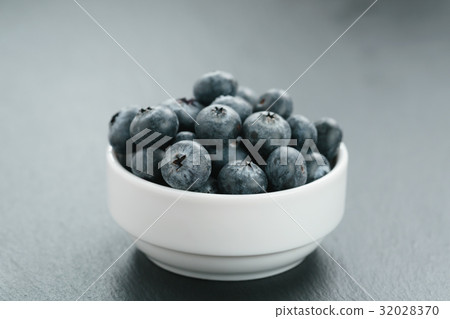 fresh blueberries in white bowl on slate board fresh blueberries in white bowl on slate board 32028370