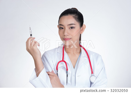 Confident smiling female doctor with a syringe in hand. Portrait of a young medical staff ready to make injection. physician or practitioner on white background Confident smiling female doctor with a syringe in hand. Portrait of a young medical staff ready to make injection. physician or practitioner on white background 32032050