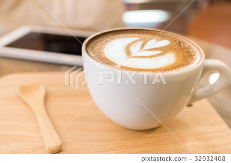 Cup of coffee with heart pattern in a white cup on wooden background 32032408