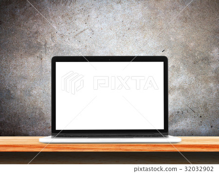 Front view of the laptop is on the work table, concrete grunge wall background. 32032902