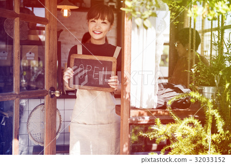Young woman holding banner open the cafe Young woman holding banner open the cafe 32033152