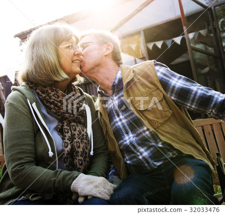 Senior Couple Man Giving Woman a Cheek Kiss Senior Couple Man Giving Woman a Cheek Kiss 32033476