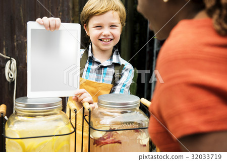 Boy selling lemonade juice at healthy product fair 32033719