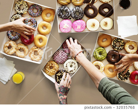 Hands selecting a variety of donut flavour 32035768
