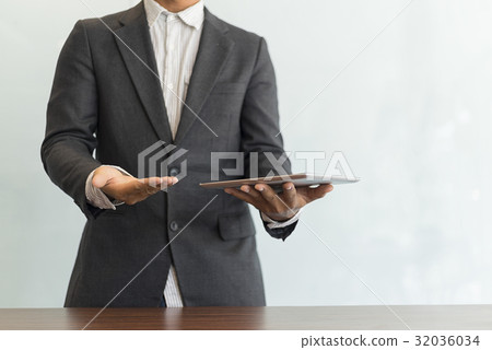 Businessman using his tablet in the office Businessman using his tablet in the office 32036034