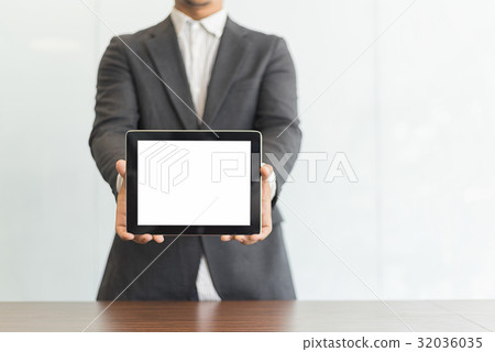 Businessman using his tablet in the office Businessman using his tablet in the office 32036035