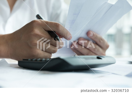 Man calculate domestic bills at home. Businessman using calculator at office. Young male checking balance and costs. Start up counting finance. Business people doing paperwork for paying taxes 32036710