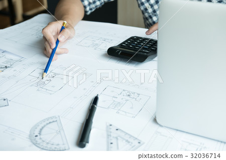 Architect working on real estate project at workplace. Male engineer hand working with living house blueprint at office. Business, people, construction and building concept Architect working on real estate project at workplace. Male engineer hand working with living house blueprint at office. Business, people, construction and building concept 32036714