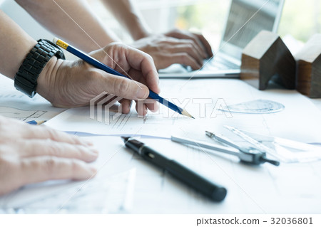Architect working on real estate project with partner at workplace. Male engineer hand working with living house blueprint at office. Business, people, construction and building concept Architect working on real estate project with partner at workplace. Male engineer hand working with living house blueprint at office. Business, people, construction and building concept 32036801