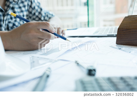Architect working on real estate project at workplace. Male engineer hand working with living house blueprint at office. Business, people, construction and building concept Architect working on real estate project at workplace. Male engineer hand working with living house blueprint at office. Business, people, construction and building concept 32036802