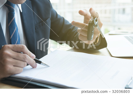 businessman sign sales contract with car key at office. ownership, customer buying and salesman selling transportation concept. businessman sign sales contract with car key at office. ownership, customer buying and salesman selling transportation concept. 32036803