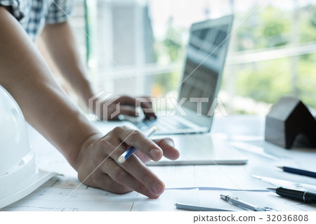 Architect working on real estate project at workplace. Male engineer hand working with living house blueprint at office. Business, people, construction and building concept Architect working on real estate project at workplace. Male engineer hand working with living house blueprint at office. Business, people, construction and building concept 32036808