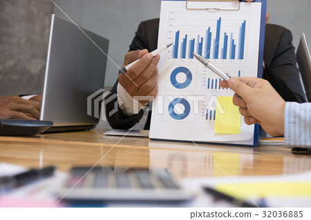 Businessman pointing at analytic financial accounting market chart. Business people present graph report summary. Start up young man shows statistics performance at office Businessman pointing at analytic financial accounting market chart. Business people present graph report summary. Start up young man shows statistics performance at office 32036885
