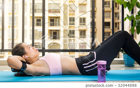 Girl doing crunches on the balcony 32044898