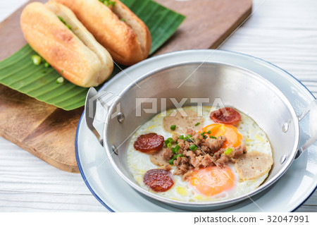 Fried eggs on pan with bread for breakfast. 32047991