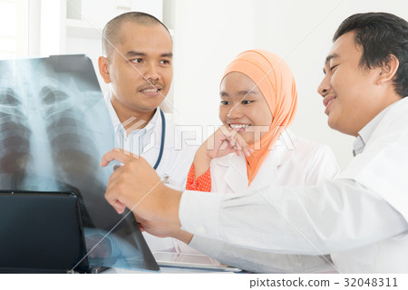Medical doctors discussing on x-ray image 32048311