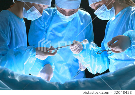 Group of surgeons at work in operating theater Group of surgeons at work in operating theater 32048438