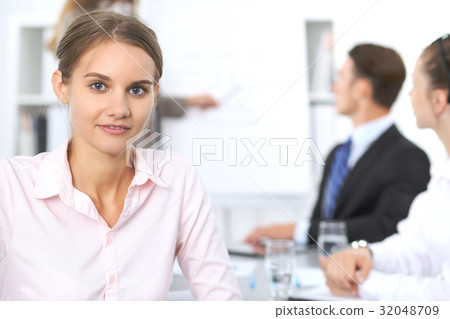 Portrait of a young business woman against a group Portrait of a young business woman against a group 32048709