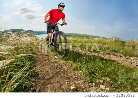 Young cyclist riding mountain bicycle through Young cyclist riding mountain bicycle through 32050558