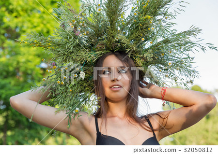Beautiful girl in wreath of wild flowers portrait. 32050812