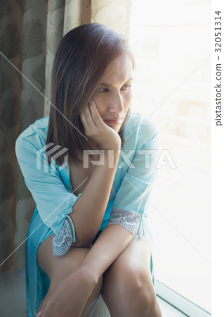 Asia people mournfully looks out her window Asia people mournfully looks out her window 32051314