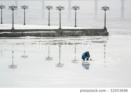 The fisherman is fishing on the ice The fisherman is fishing on the ice 32053696