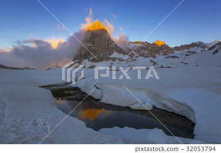 Sunlit peak among snow area Sunlit peak among snow area 32053794