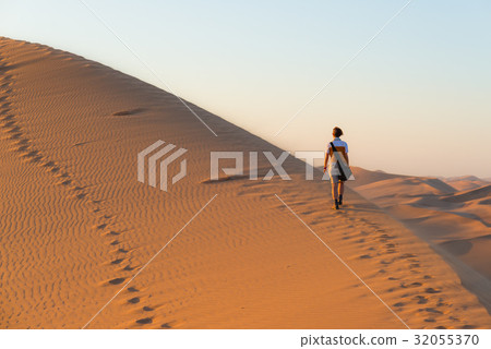 Tourist walking on the scenic dunes of Sossusvlei 32055370