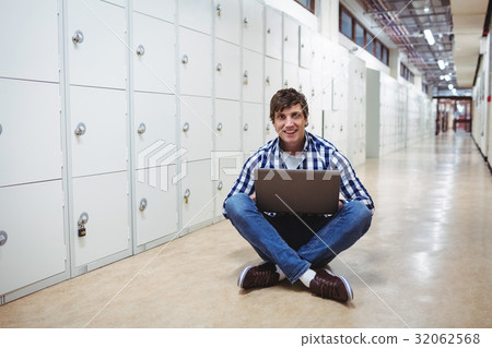 Student using laptop in locker room Student using laptop in locker room 32062568