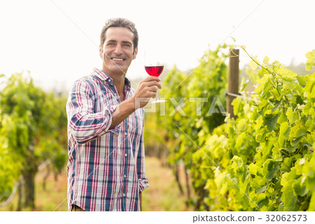 Smiling vintner holding glass of wine Smiling vintner holding glass of wine 32062573