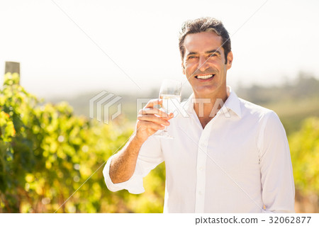 Portrait of smiling male vintner holding a glass of wine 32062877