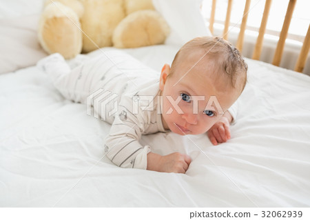 Baby lying on baby bed 32062939