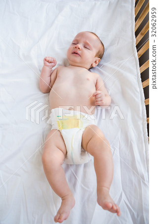 Baby lying on baby bed 32062959
