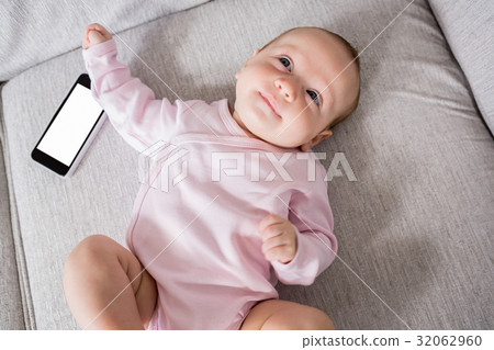 Baby lying on sofa in living room 32062960