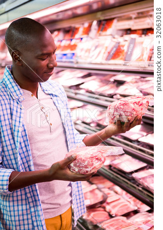 Man looking at goods in grocery section while shopping 32063018