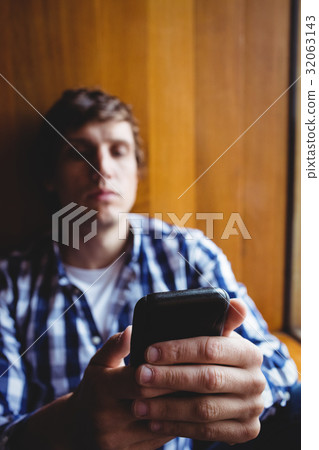 Student using mobile phone near window 32063143