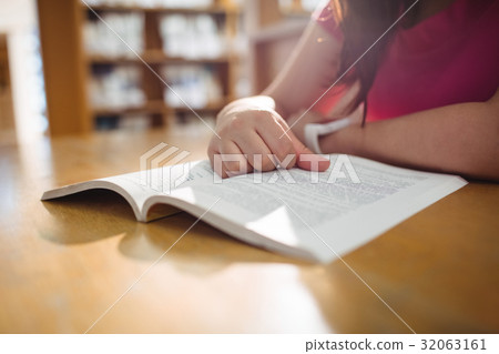 Female student reading book in college library Female student reading book in college library 32063161