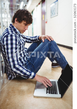 Student using laptop in locker room 32063173