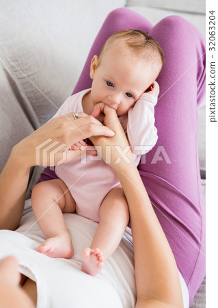 Mother playing with her baby in bedroom 32063204