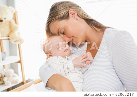 Mother holding and embracing her baby boy Mother holding and embracing her baby boy 32063217
