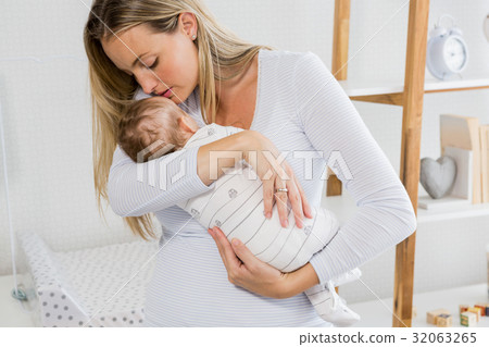 Mother holding and kissing her baby boy 32063265