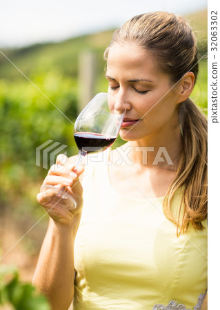 Female vintner smelling glass of wine 32063302