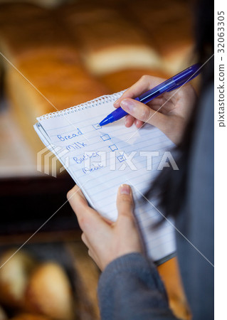 Mid section of woman marking on checklist 32063305