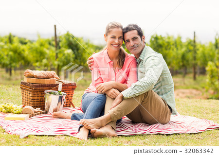 Portrait of happy couple relaxing on a blanket Portrait of happy couple relaxing on a blanket 32063342